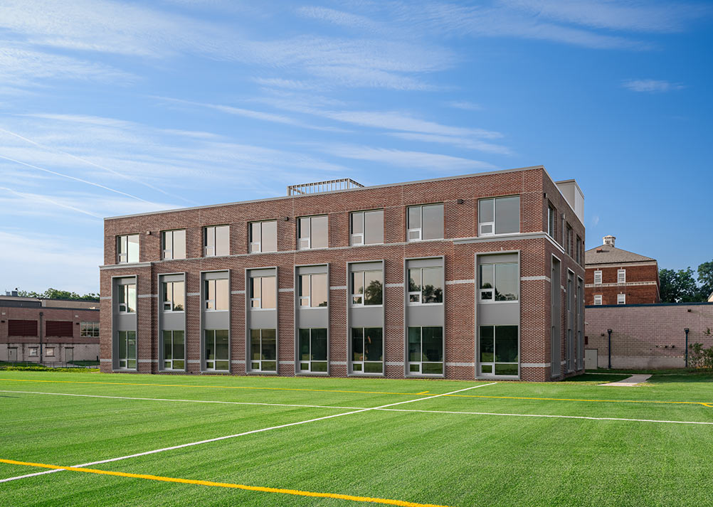 A close up of the exterior, featuring classic brick with modern, large windows.
